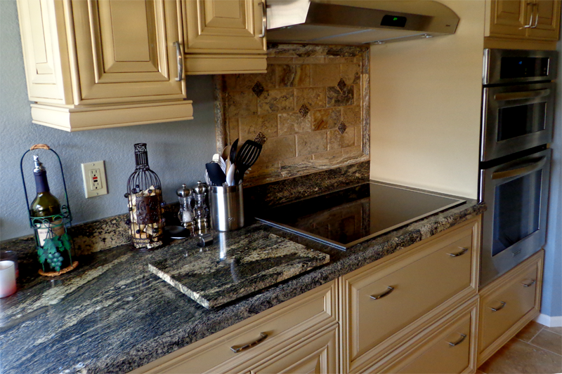 Granite counter top Juparana Sunset complementing beige kitchen cabinets