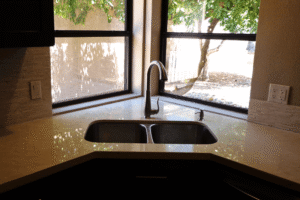 Granite kitchen countertops in a Phoenix AZ home featuring an undermount double sink and natural light