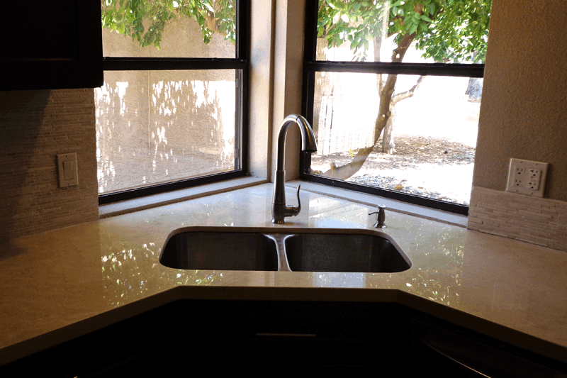 Granite kitchen countertops in a Phoenix AZ home featuring an undermount double sink and natural light