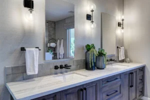 Double undermount sink granite bathroom vanity tops with gray cabinetry, matte black faucets, and modern wall sconces in a Phoenix master bathroom.